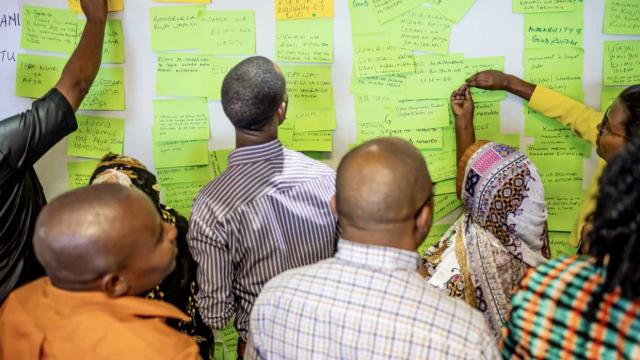 Pact staff and community members in Tanzania take part in a workshop before the Covid-19 pandemic to gather ideas for improving Pact’s programming